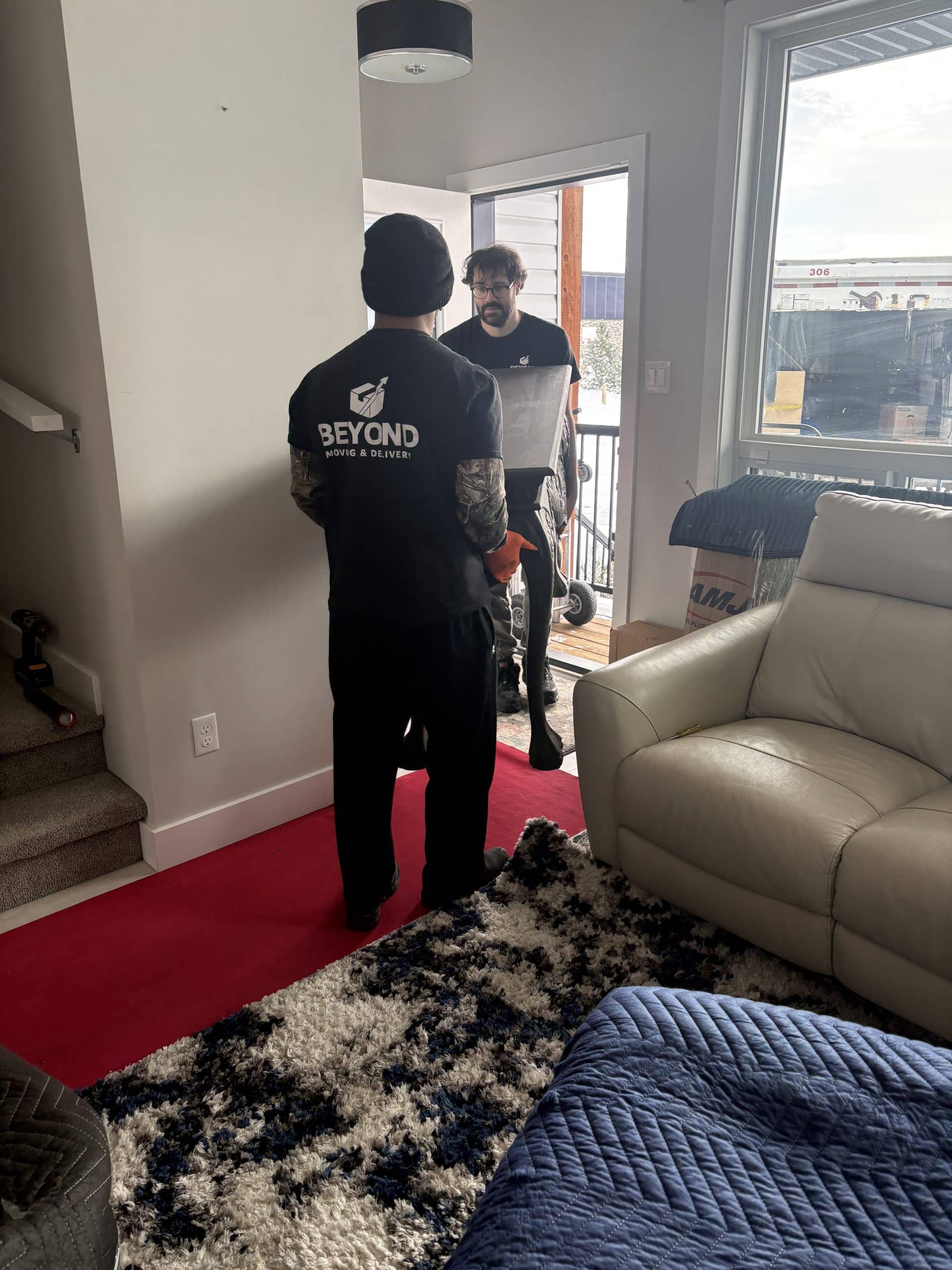 Movers carrying equipment into a home with protection