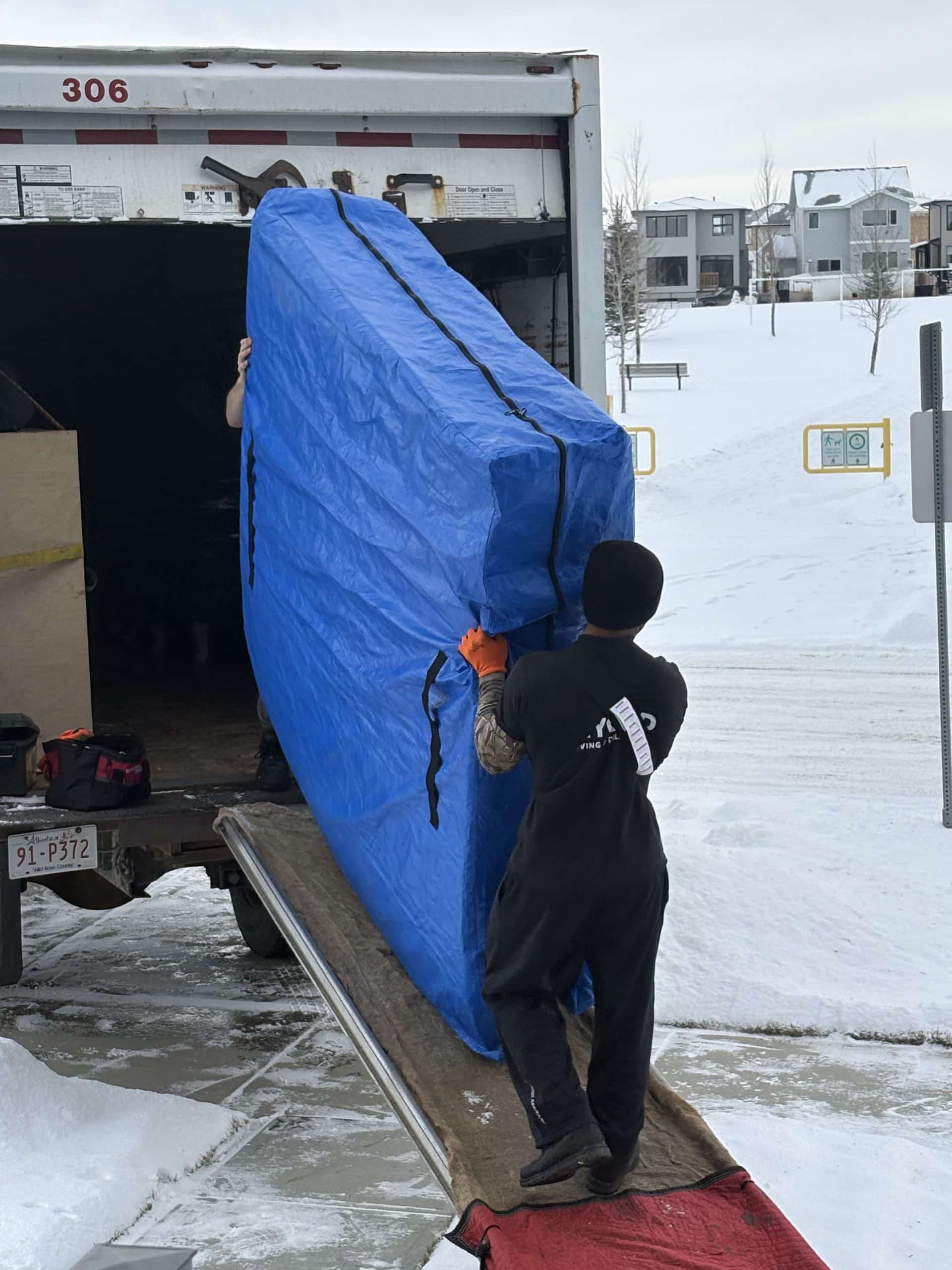 Beyond Moving crew loading a protected large item into a moving truck